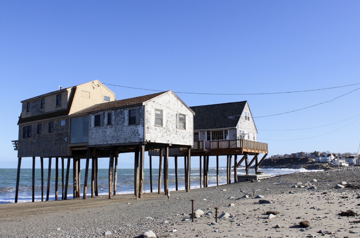Beach houses raised on stilts with the ocean running underneath